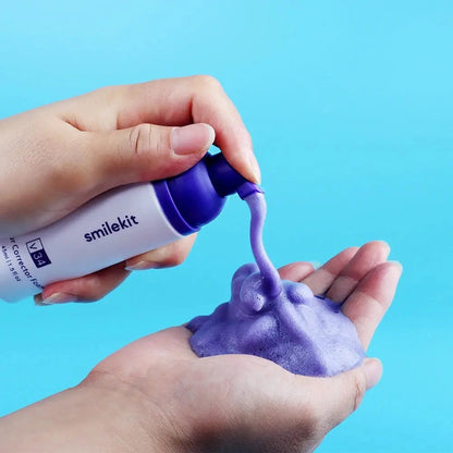 V34 Color Corrector Foam being dispensed onto hand, showcasing its purple color and foamy texture.