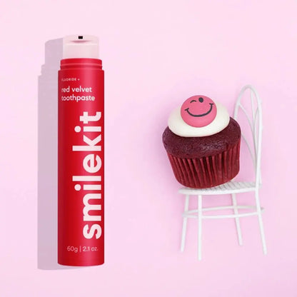 Smilekit red velvet toothpaste with cupcake against pink background.