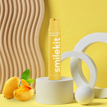 Smilekit mango sorbet toothpaste with fluoride for cavity protection placed on a modern, yellow-themed background.